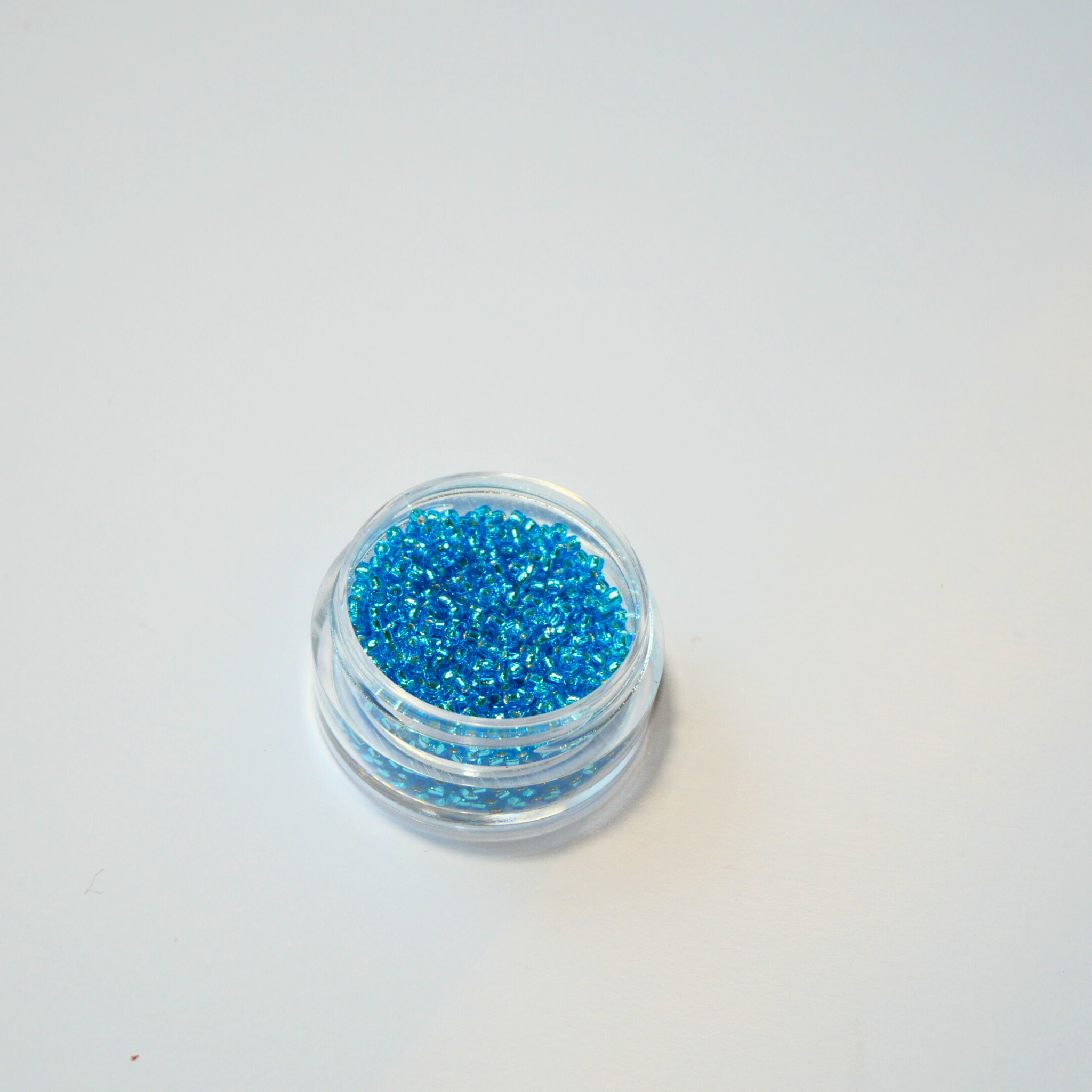 TOHO 15/0 ümmargused mikro-klaaspärlid, hõbedase südamikuga tume akvamariinisinine (Dark Aqua), värvikood 23B.