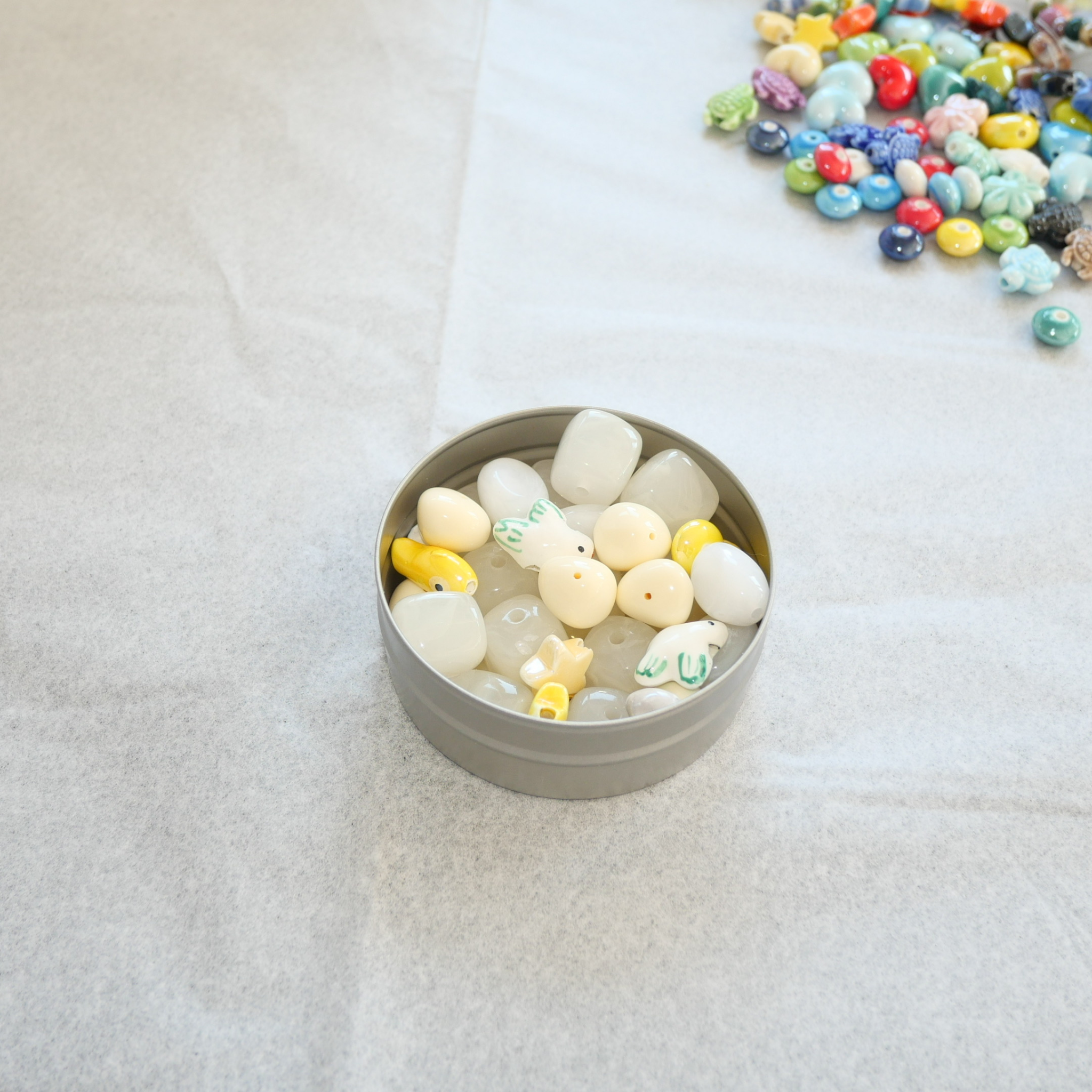 Heledates valgetes ja kollakates toonides helmed kumminiidil käeehete valmistamiseks, Eesti käsitööst inspireeritud DIY käevõru komplekt.