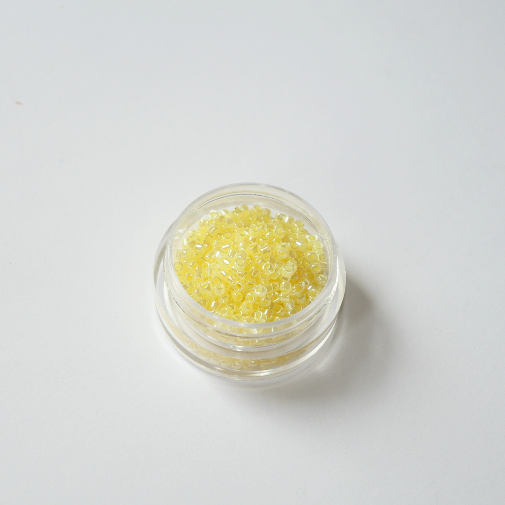 Miyuki Delica 11/0 koodiga DB-232. Detailne lähivõte pärljatest ja jahedatest sidrunikollastest (Light Lemon Ice Ceylon) silindrilistest helmestest.