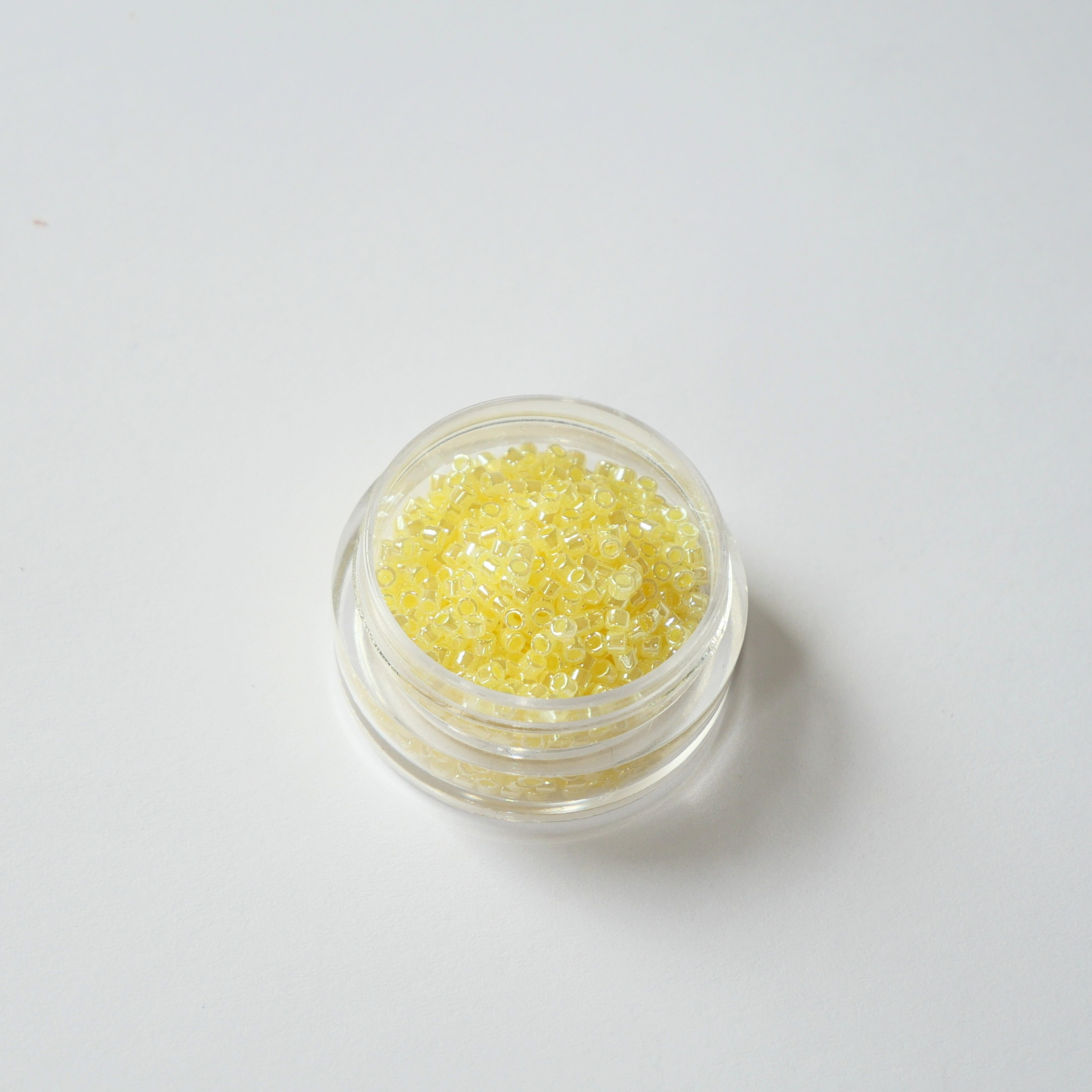 Miyuki Delica 11/0 koodiga DB-232. Detailne lähivõte pärljatest ja jahedatest sidrunikollastest (Light Lemon Ice Ceylon) silindrilistest helmestest.