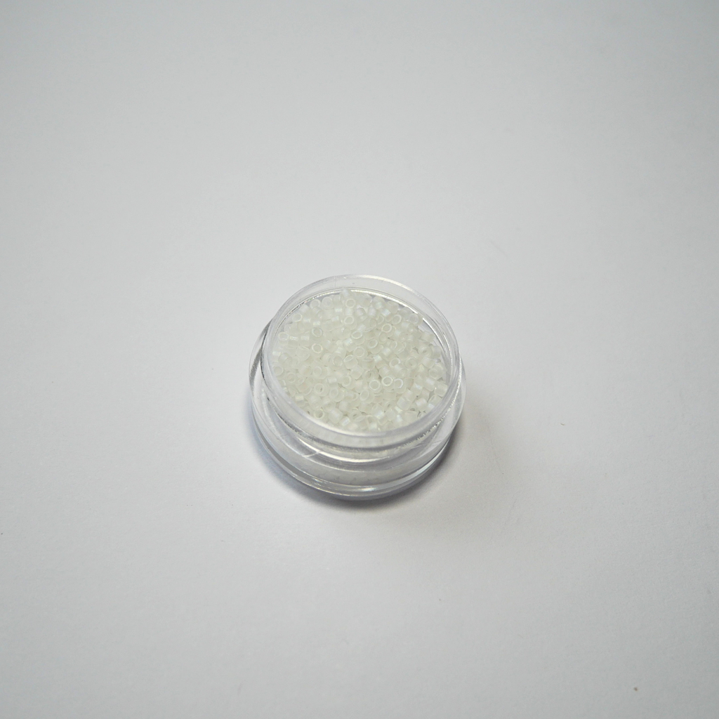 Miyuki Delica 11/0 koodiga DB-0851. Detailne lähivõte mattidest läbipaistvatest vikerkaarelise AB-läikega (Mat Crystal AB) silindrilistest helmestest.